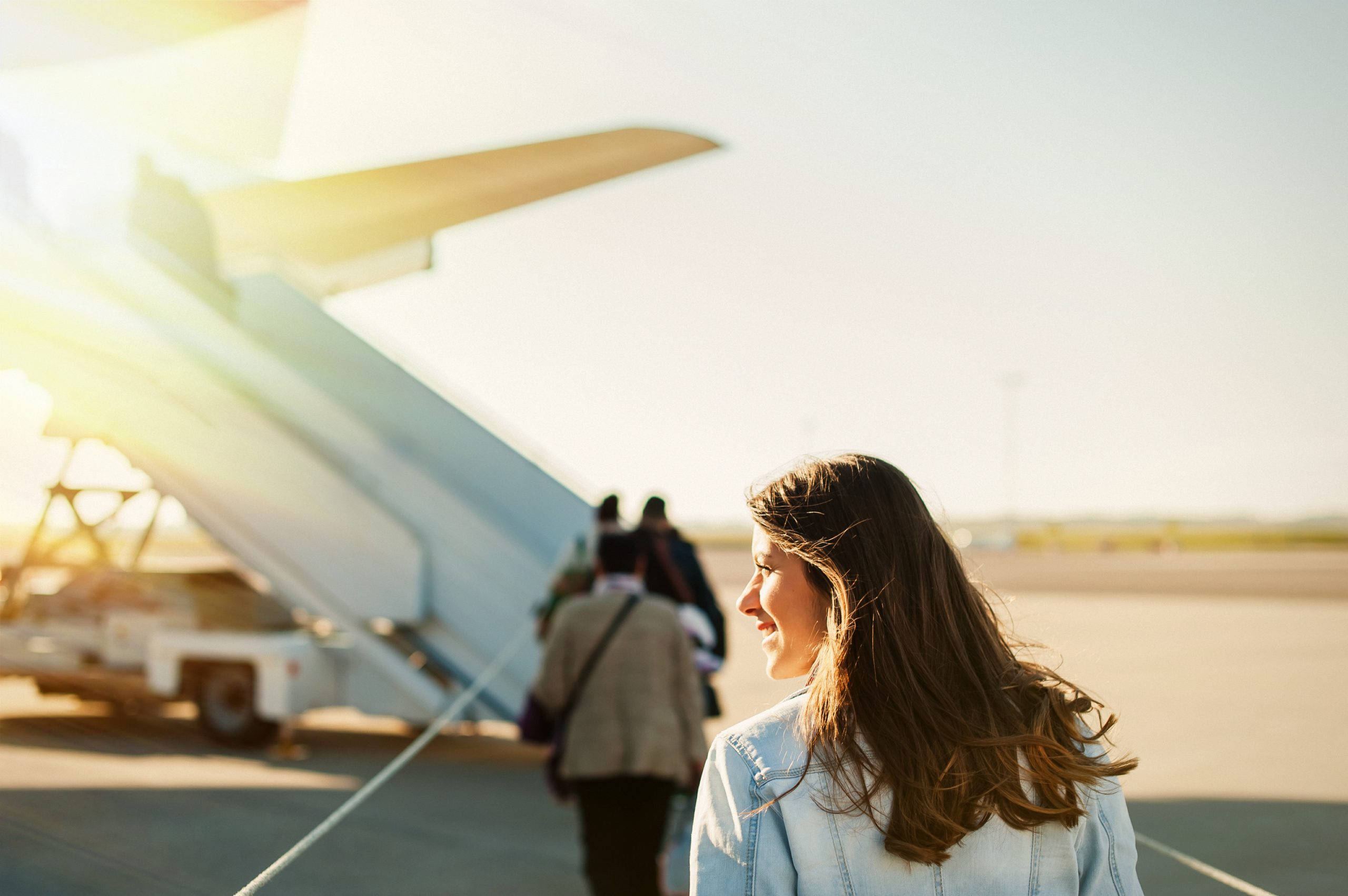 Young woman passager walking from the airport terminal to the ai